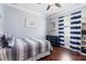 Comfortable bedroom with hardwood floors, a ceiling fan, striped bedding, and a navy-blue dresser at 2956 Falconhill Dr, Apopka, FL 32712