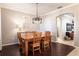 Dining room with dark wood floors, wooden table, natural light and stylish light fixture at 2956 Falconhill Dr, Apopka, FL 32712