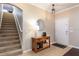 Welcoming foyer with a staircase, console table, decorative mirror, and neutral tile flooring at 2956 Falconhill Dr, Apopka, FL 32712