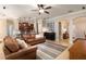 Inviting living room with tan sofas, tile floors, ceiling fan and an open floorplan with views into the kitchen at 2956 Falconhill Dr, Apopka, FL 32712