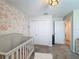 Bedroom featuring a crib, floral wallpaper, and closet at 3055 Aqua Virgo Loop # 47, Orlando, FL 32837