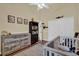 Cozy bedroom with wood floors, a rustic dresser, and a crib near bright windows at 322 Harbor Trl, Enterprise, FL 32725