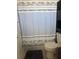 Compact bathroom features a combination of shower, toilet, and storage solutions for convenience at 345 W Seminole Ave, Eustis, FL 32726