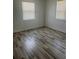 Bright bedroom features wood-look flooring and natural light from two windows at 345 W Seminole Ave, Eustis, FL 32726