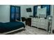 Well-lit bedroom featuring a dresser, mirror, and wood-look flooring at 345 W Seminole Ave, Eustis, FL 32726
