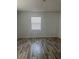 Bright, airy bedroom with wood-look floors and a single window at 345 W Seminole Ave, Eustis, FL 32726