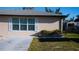 Exterior of house, showing a low brick wall and neatly manicured plants with a sunny sky at 345 W Seminole Ave, Eustis, FL 32726