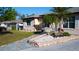 Well-maintained front yard with a stone pathway and colorful landscaping and a walkway to the front door at 345 W Seminole Ave, Eustis, FL 32726