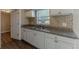 Modern kitchen featuring sleek white cabinets, beautiful backsplash, and stainless steel appliances at 3706 Wade Rd, Orlando, FL 32808
