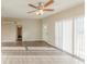 Well-lit living room with ceiling fan, sliding doors, and wood-look floors at 3706 Wade Rd, Orlando, FL 32808