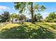 Expansive backyard with lush green lawn, mature trees, and charming exterior view at 407 E Jersey St, Orlando, FL 32806
