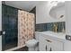 Stylish bathroom featuring dark tile, a shower with a floral curtain, and gold fixtures at 407 E Jersey St, Orlando, FL 32806