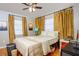 Warm bedroom with hardwood floors, natural colors, and two windows with gold drapes at 407 E Jersey St, Orlando, FL 32806