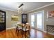 Cozy dining area with hardwood floors, a modern chandelier, and access to an outdoor patio at 407 E Jersey St, Orlando, FL 32806