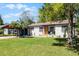 Beautiful one-story home showcasing a bright orange door and a well-maintained yard, providing a welcoming curb appeal at 407 E Jersey St, Orlando, FL 32806