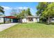 Charming single-story home featuring a well-manicured lawn and a covered carport, perfect for easy parking at 407 E Jersey St, Orlando, FL 32806