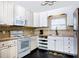Functional kitchen with white cabinets, stainless steel appliances, and a dark wood floor at 407 E Jersey St, Orlando, FL 32806