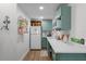 Charming kitchen features sage green cabinetry, quartz countertops, and modern appliances at 407 E Jersey St, Orlando, FL 32806