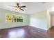 Well-lit bedroom featuring hardwood floors, a ceiling fan, and a large window with outdoor views at 4550 Chandler Rd, Apopka, FL 32712