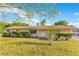 Inviting single-story home with a well-maintained lawn and manicured hedges, set against a blue sky at 4550 Chandler Rd, Apopka, FL 32712