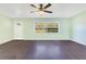 Bright living room with hardwood floors, a ceiling fan, and a large window showcasing the outdoor view at 4550 Chandler Rd, Apopka, FL 32712