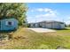 Spacious backyard featuring a storage shed, concrete pad, and well-maintained lawn at 4751 Deer Run Rd, St Cloud, FL 34772