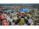 Aerial view of a community clubhouse, pool, and surrounding residential area with mature landscaping and water features at 4761 Ormond Beach Way, Kissimmee, FL 34746