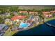 Aerial view of a community with a large pool, clubhouse, and surrounding residential buildings near a lake at 4761 Ormond Beach Way, Kissimmee, FL 34746