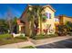 Charming yellow townhome with lush landscaping, a tile roof, and a cozy front porch at 4761 Ormond Beach Way, Kissimmee, FL 34746