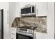 Modern kitchen featuring stainless appliances and beautiful marble countertops and backsplash at 4761 Ormond Beach Way, Kissimmee, FL 34746