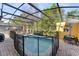 A serene screened-in pool with brick pavers and garden views providing privacy at 4761 Ormond Beach Way, Kissimmee, FL 34746