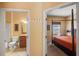Hallway view showcasing the bathroom with tile floors and a bedroom featuring a four-poster bed with carpeted floors at 4772 Vero Beach Pl, Kissimmee, FL 34746