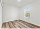 Sunlit bedroom with hardwood floors and a window overlooking the trees at 4774 Sw 142Nd Place Rd, Ocala, FL 34473