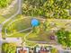 Aerial shot of a bright blue community pool encircled by walking paths and trees in a green park at 4774 Sw 142Nd Place Rd, Ocala, FL 34473