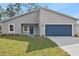 Charming single-story home with a blue door and a well-manicured front yard at 4774 Sw 142Nd Place Rd, Ocala, FL 34473