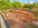 Aerial view of a well-equipped playground with swings, slides, and various play structures surrounded by lush greenery at 4774 Sw 142Nd Place Rd, Ocala, FL 34473