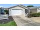 Attached garage and screened in porch with a manicured yard in a well-maintained community at 480 Hildalgo Dr, The Villages, FL 32159