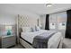 Bright bedroom features a large, tufted headboard, grey accents, and natural light from the window at 5117 Killarney Way, Kissimmee, FL 34746