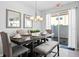 Dining room with seating for six, a modern chandelier and an exit door at 5117 Killarney Way, Kissimmee, FL 34746