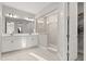 Modern bathroom with double vanity, frameless glass shower, and a view to the closet at 543 Wishbone Ln, Lake Mary, FL 32746