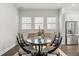 Bright dining room features a round table, six chairs, and natural light from three large windows at 543 Wishbone Ln, Lake Mary, FL 32746