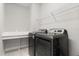 Functional laundry room with a modern washer and dryer set and built-in shelving for organized storage at 543 Wishbone Ln, Lake Mary, FL 32746