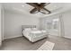 A calm main bedroom with a tray ceiling and ceiling fan boasts great natural light from two windows at 543 Wishbone Ln, Lake Mary, FL 32746