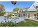 A serene backyard showcases a sparkling pool with a fire pit and a spacious white home exterior at 571 N Lake Sybelia Dr, Maitland, FL 32751