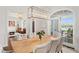 Dining room features a wood table, upholstered chairs, lake views, and a modern chandelier at 571 N Lake Sybelia Dr, Maitland, FL 32751