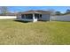 A view of the backyard featuring a screened-in porch, spacious lawn and a white fence at 6 Almond Trce, Ocala, FL 34472