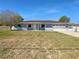 Charming one-story home with blue exterior, white trim, brown roof, and attached garage at 6 Almond Trce, Ocala, FL 34472