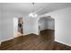 Open living room with wood floors, stylish chandelier, and easy access to the kitchen at 6 Almond Trce, Ocala, FL 34472
