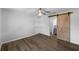 Spacious main bedroom with wood floors and modern barn door entry to the bathroom at 6 Almond Trce, Ocala, FL 34472