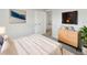 Bright bedroom featuring neutral walls, soft carpet, a dresser, and a wall-mounted television at 6003 W Harwood Ave, Orlando, FL 32835